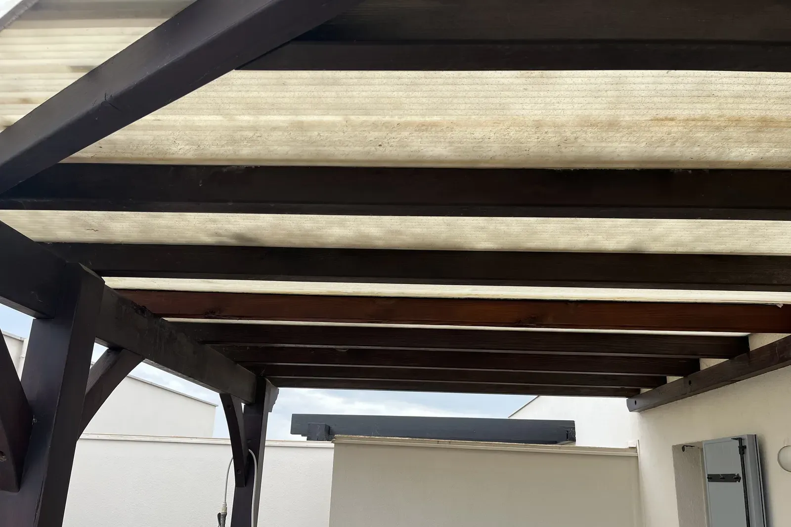 Réparation de pergola en bois en sous-œuvre à Saint-Cyprien (66) : traverse remplacée sans retirer la couverture, au 3ᵉ étage d’un immeuble.